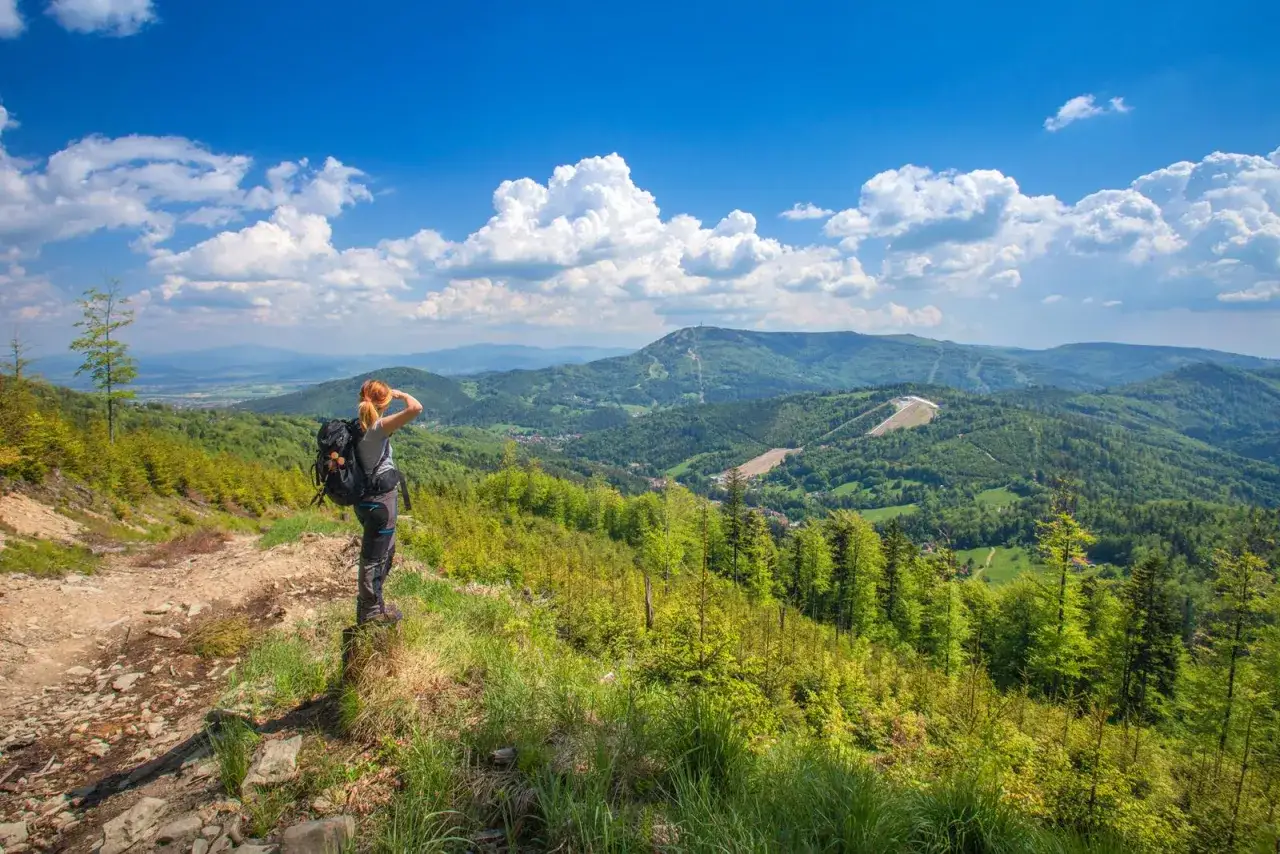 Widok na góry i doliny w Szczyrku i okolicach. Turystka podziwia panoramę, odkrywając atrakcje Beskidów.