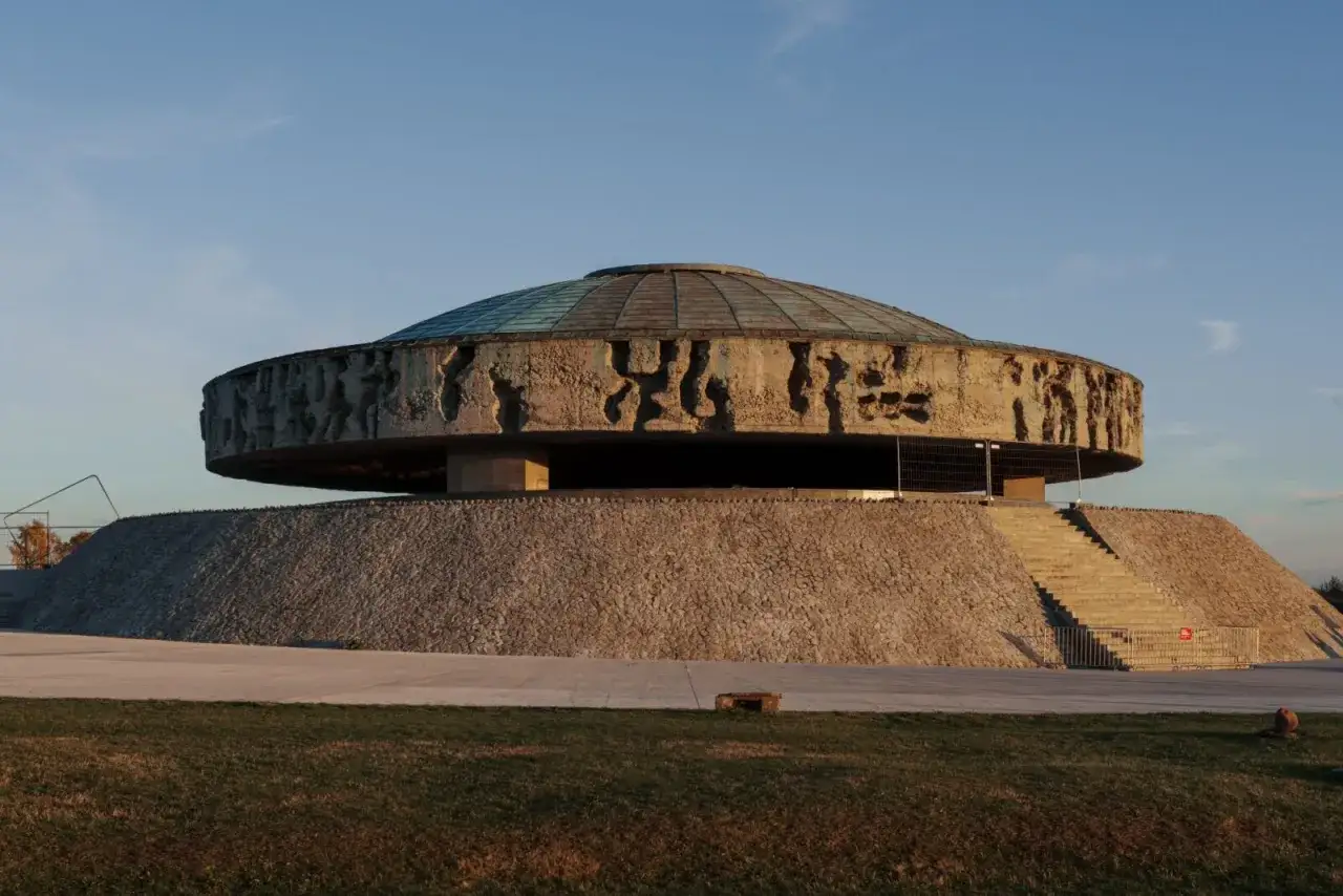 Pomnik w byłym obozie Majdanek. Monumentalna budowla z betonowym pierścieniem i płaskorzeźbami, przypominająca o tragedii.