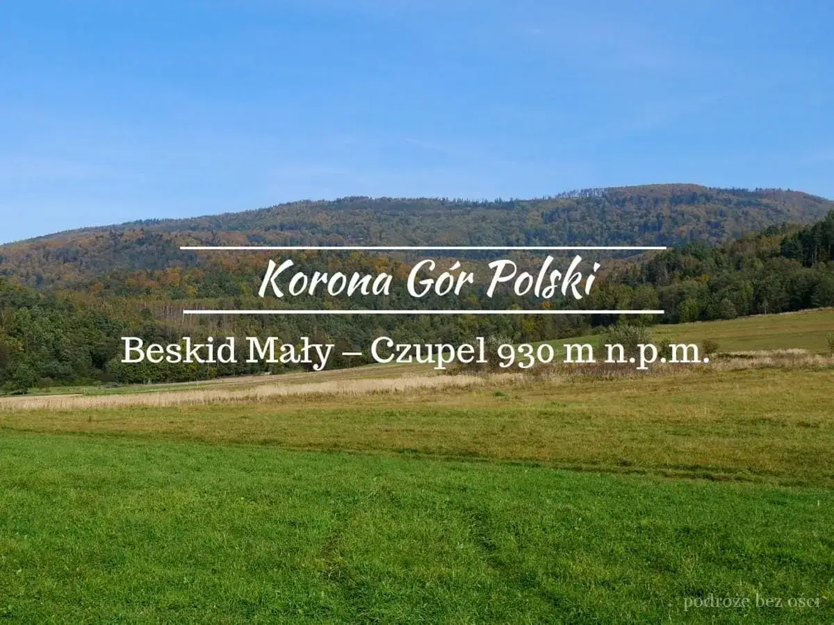 Beskid Mały – Czupel 930 m n.p.m. w Koronie Gór Polski. Zielone łąki i zalesione wzgórza pod błękitnym niebem.