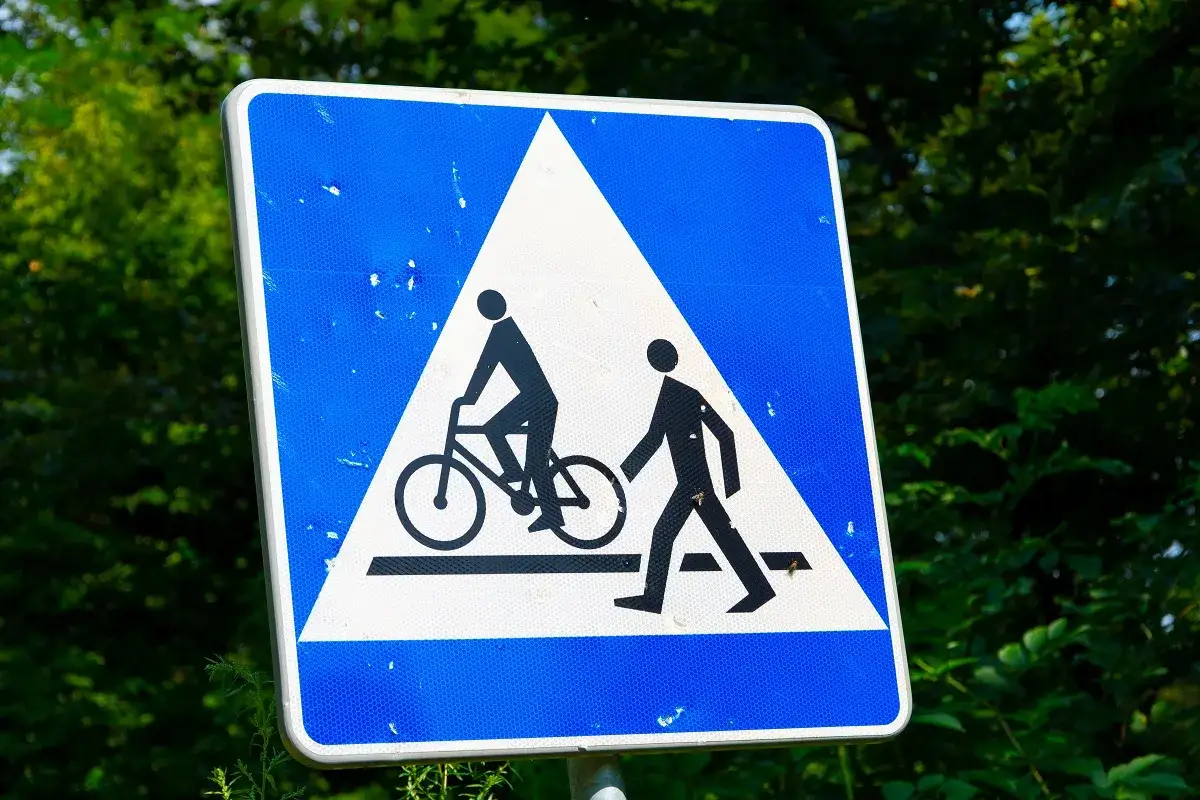 Znak ostrzegawczy: przejazd dla rowerzystów i pieszych. Czy rowerzysta ma pierwszeństwo na przejeździe rowerowym? Ten znak informuje o tym, że należy zachować ostrożność.